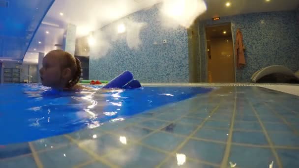 A menina está treinando na piscina usando equipamentos de esportes aquáticos — Vídeo de Stock