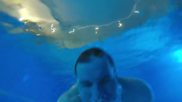 Człowiek jest pływanie pod wodą z jego oczy zamknięte — Wideo stockowe