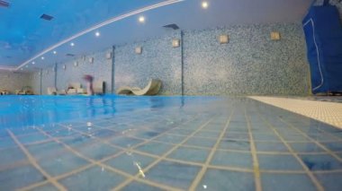 Adam havuzda sürünerek yüzüyor.