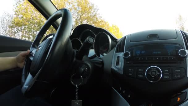 Mão feminina esquerda está segurando o volante do carro Chevrolet, enquanto dirige — Vídeo de Stock