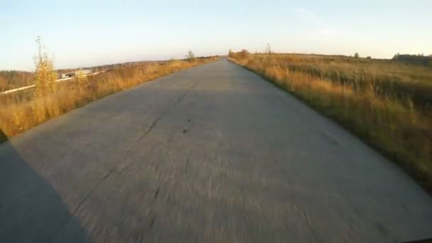 Há o passeio ao longo da estrada de asfalto no campo. Vista em primeira pessoa — Vídeo de Stock