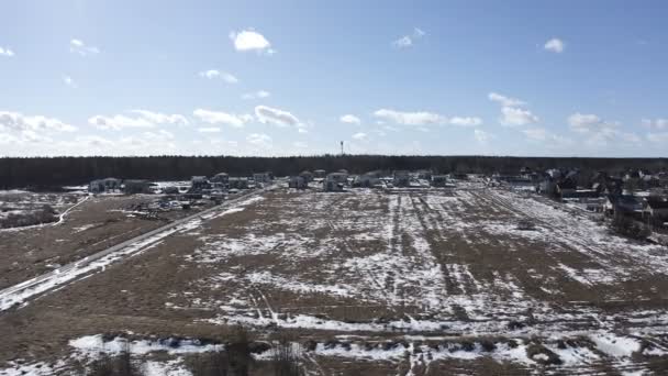 Leeg besneeuwde winter veld met residentiële gebouwen aan de rand — Stockvideo