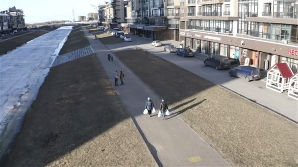 人々は新しい住宅街の運河に沿って歩行者通路に沿って歩いている — ストック動画