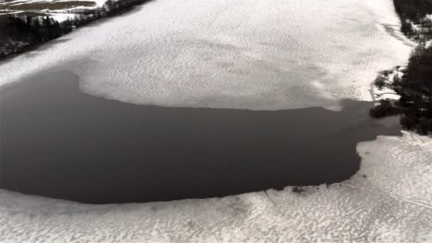 La corriente del río hace su camino a través de las capas de hielo del invierno — Vídeos de Stock
