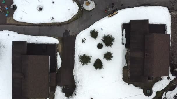 En medio de dos casas, entre la nieve, se ven arbustos fragantes — Vídeos de Stock