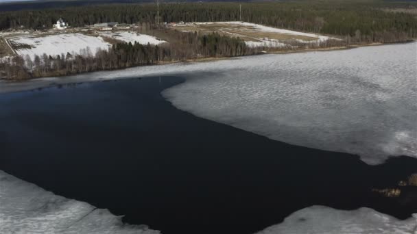 Течение реки плавно размывает толстый лед в весенний паводок — стоковое видео