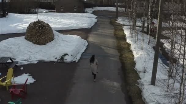 Fille sautant joyeusement marcher le long de la rue dans le village de chalet — Video