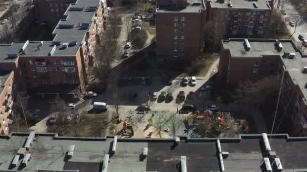 Utsikt över ett bostadsområde med tegelhus och parkerade bilar på innergårdarna — Stockvideo