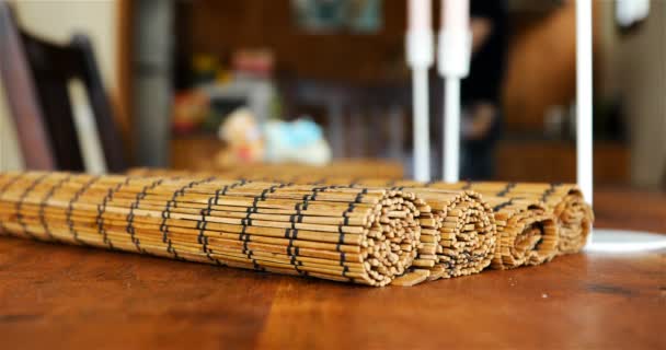Skręcone bambusowe dywan na stole. Pierwszym planie — Wideo stockowe