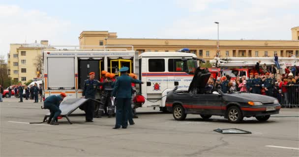 Rescatadores poner herramientas y equipos en el coche, y el Ministerio de Emergencia limpia el sitio después de un accidente de coche — Vídeo de stock