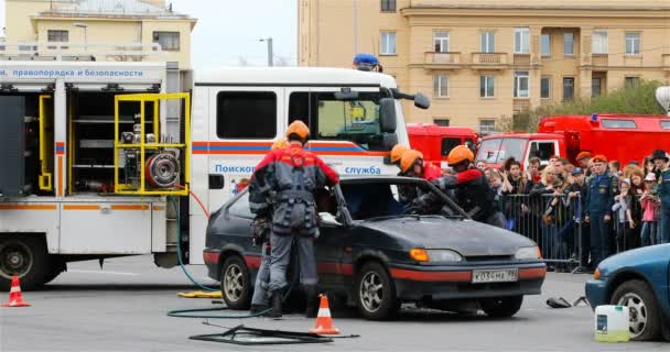 Profesionales del servicio de rescate cortan el metal de la carrocería del coche con tijeras hidráulicas — Vídeo de stock