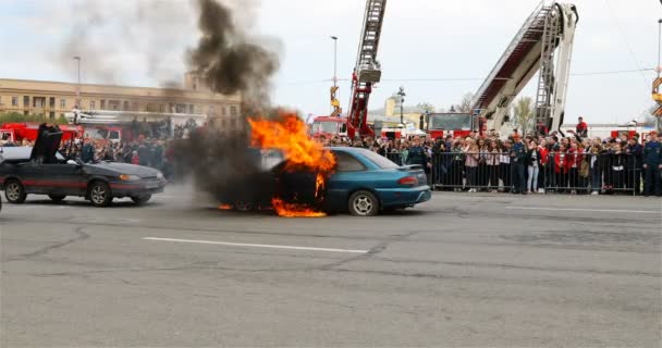 Požární důstojník s hasicím přístroji uhasící oheň z vozu — Stock video