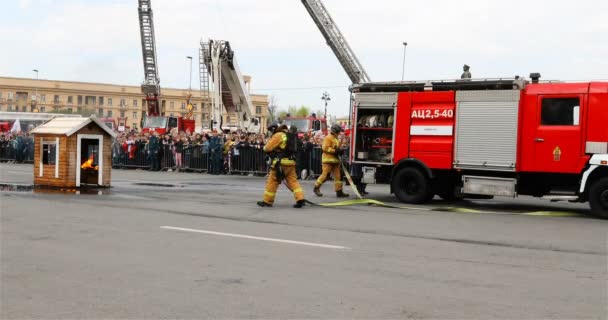 消防隊員は、自動車の設置に消火システムを接続します — ストック動画