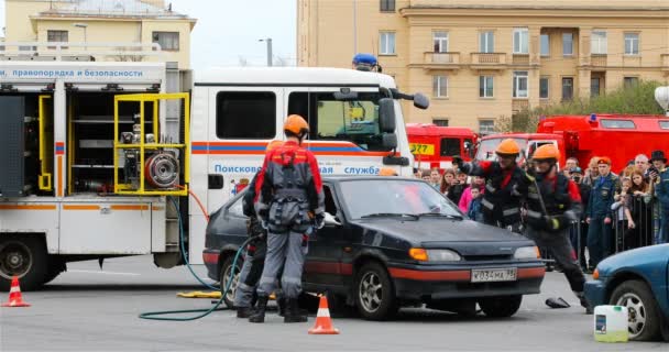 Спасательная служба разбивает лобовое стекло автомобиля, чтобы проникнуть в автомобиль — стоковое видео
