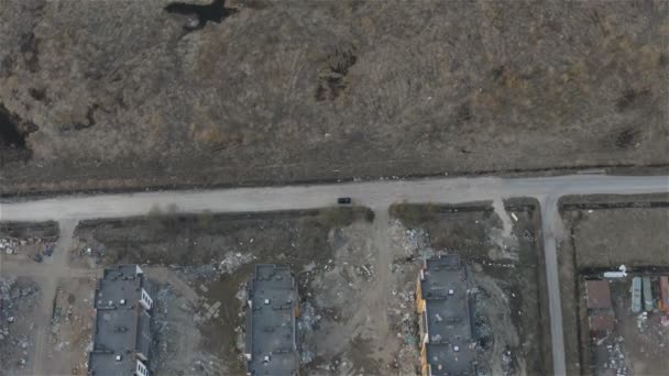 Een auto beweegt op een suburbane weg in de buurt van een bouwplaats — Stockvideo