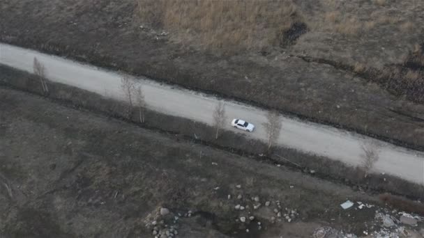 Водитель белой машины аккуратно едет по коварной дороге — стоковое видео