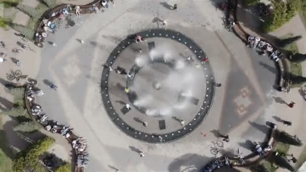 Les gens se reposent dans une zone de parc assis à une fontaine — Video