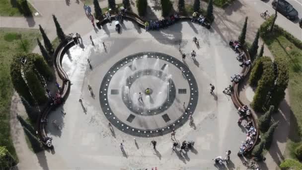 Tourists and passers-by enjoy the water from the fountain jumping and dancing under the jets of water — Stock Video