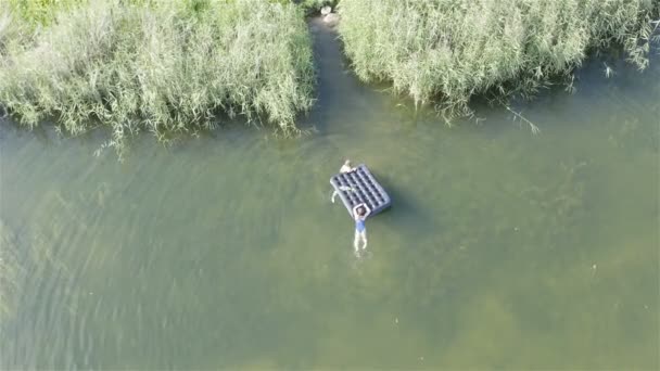 Frauen mit Luftmatratze schwimmen ans Ufer. Top-Schuss — Stockvideo