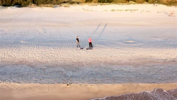 Na costa junto ao mar, um homem e uma mulher respiram ar fresco — Vídeo de Stock
