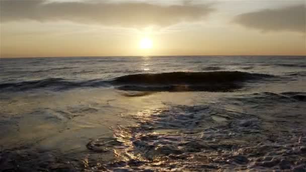 Ondas do mar são lavadas em terra ao pôr do sol — Vídeo de Stock