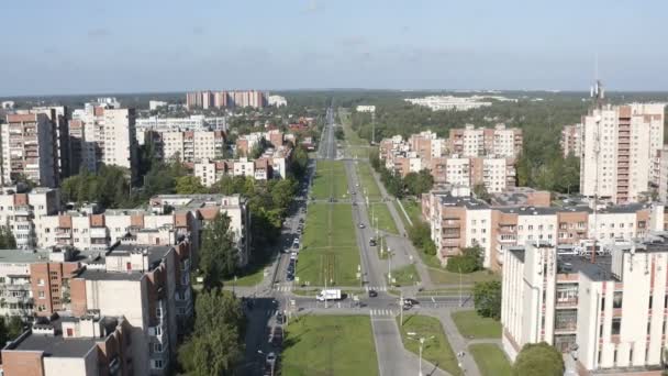 A avenida central da cidade com um beco verde que separa os lados direito e esquerdo da estrada — Vídeo de Stock