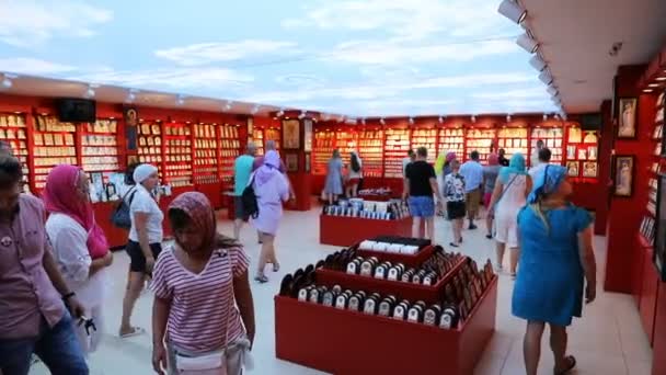 Turistas en una tienda comprando iconos sagrados en una tienda de la iglesia — Vídeo de stock