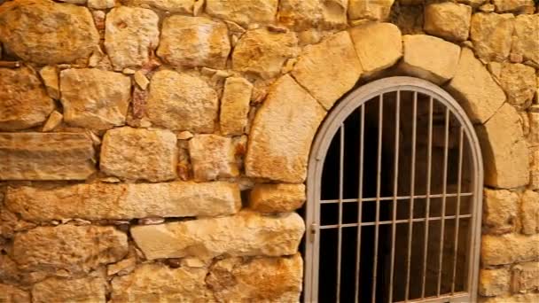 Oude muren van een historisch gebouw gemaakt van stenen met ijzeren deuren gemaakt van bars — Stockvideo