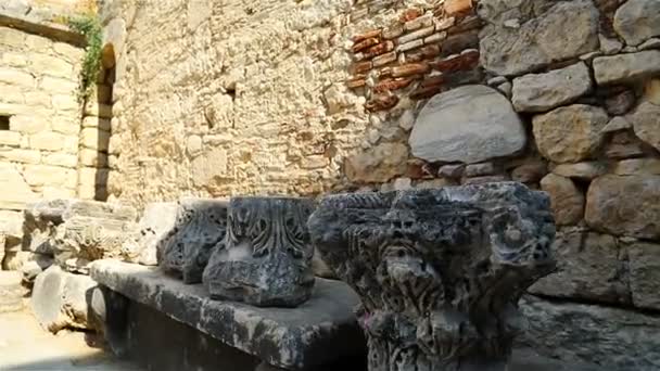 Stones and slabs with fragments of columns along the historic wall of the castle — ストック動画