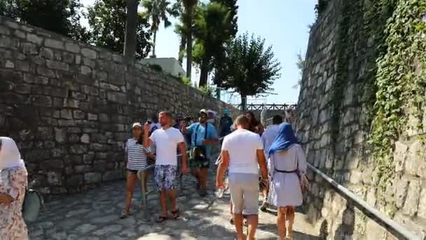 Turisták elhagyják a templomot Szent Miklós mászik fel a kő vak területen — Stock videók