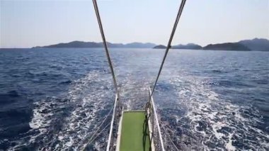 Yelken açarken, tekne dalgalar ve uzun bir deniz yolu bırakır.