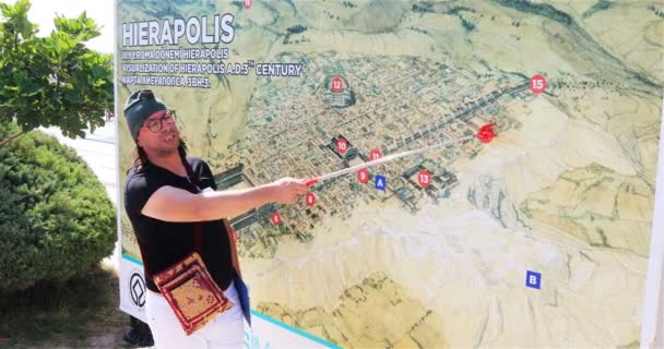 Le guide sur la carte montre et raconte l'histoire de l'origine de la ville de Hierapolis — Video