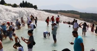 Su, doğal teraslar ve banyolar oluşturan kalsiyum karbonatla doymuş.