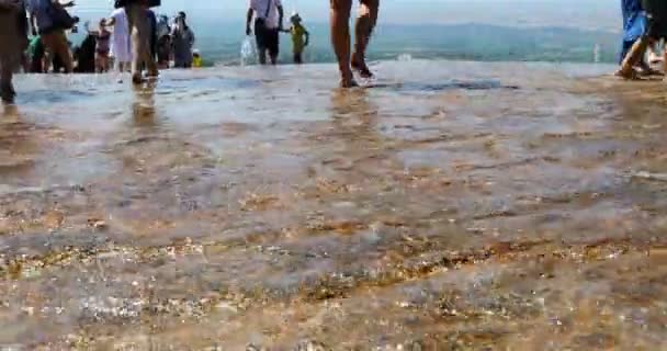 Op travertijn terrassen met warm water, toeristen lopen alleen op blote voeten — Stockvideo