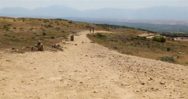Uzun bir dağ yolu boyunca dağlardan inen gezginler