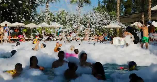 Ludzie tańczący i pływający w basenie z pianką na imprezie hotelowej — Wideo stockowe