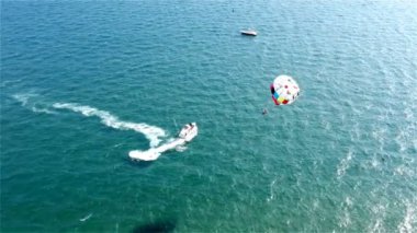 İki turist deniz paraşütünden çok zevk alır.