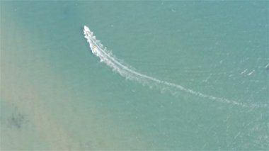 Tekne, turistlerle dolu şişme lastik bir tekneyi yüksek hızda dalgalar boyunca çeker.