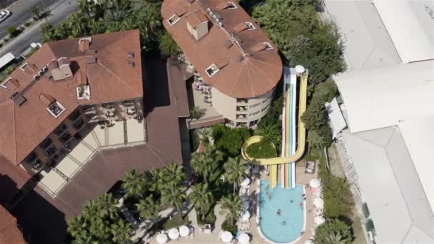 Children with parents ride a water slide diving into the pool. Top shot — ストック動画