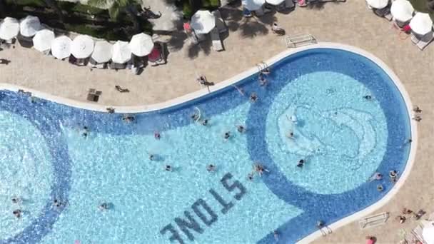 Erwachsene und Kinder führen Wassergymnastik im Pool durch, bei der die Turnübungen des Trainers wiederholt werden — Stockvideo