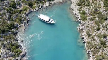 Bir yatla gelen turistler ıssız bir adanın kıyısında yüzüyorlar.