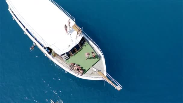 Туристы отдыхают на борту экскурсионного судна в открытом море под палящим солнцем — стоковое видео