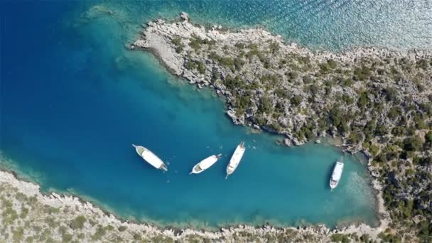 Quatro iates trouxe turistas para uma ilha de pedra para umas férias tranquilas no mar na lagoa azul — Vídeo de Stock