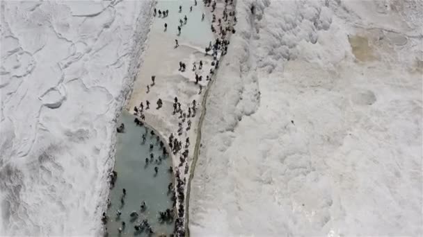 Kar beyazı sarkıtlar ve kalsit akıntıları termal su ile banyo şeklinde tuhaf ve benzersiz çağlayanlar oluşturur. — Stok video