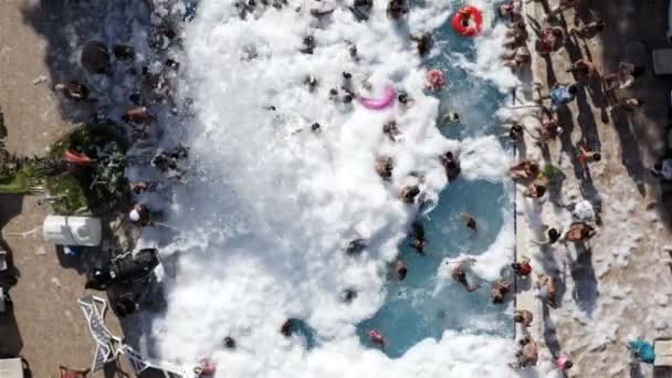 Bambini e adulti con famiglie fanno il bagno in una piscina piena di schiuma saponata — Video Stock