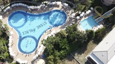 Açık havuz ve açık mavi su taştan saray tatil köyünde.