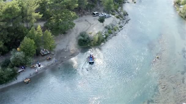 Sportowcy cumować nadmuchiwaną łódź do skalistego brzegu dla relaksu — Wideo stockowe