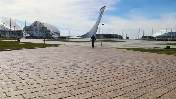 Egy férfi sétál át a Szocsi Olimpiai Parkon. — Stock videók