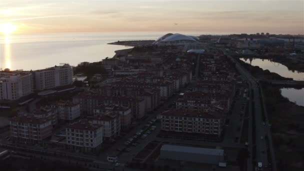 The plane flies against the background of a coastal city — Stock Video