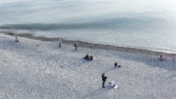 Touristes par temps frais se détendre sur la plage — Video